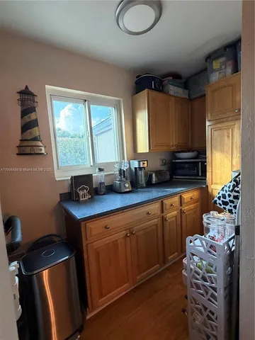a kitchen with stainless steel appliances a sink window and cabinets