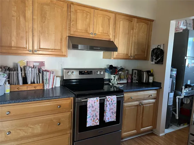 a kitchen with granite countertop a stove and a sink