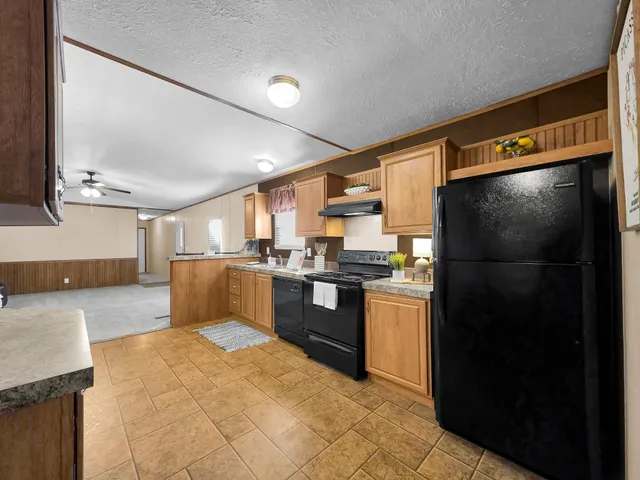 a kitchen with granite countertop a sink cabinets and stainless steel appliances