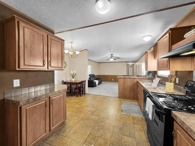 a kitchen with stainless steel appliances granite countertop a stove a sink dishwasher and cabinets with wooden floor