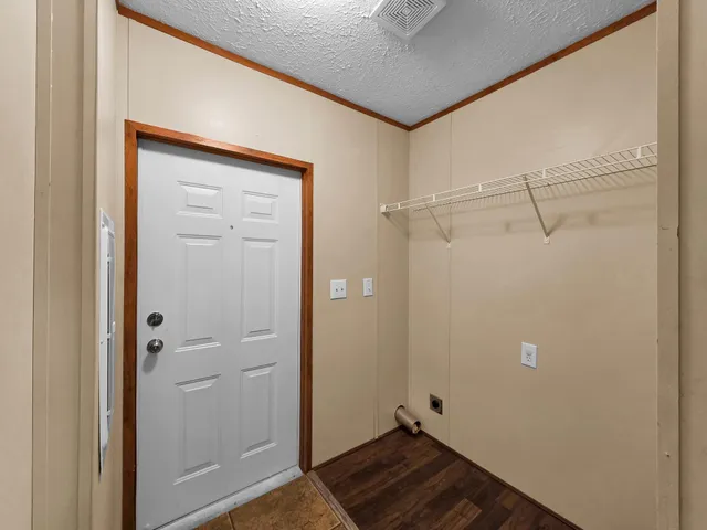 an empty room with windows and chandelier fan