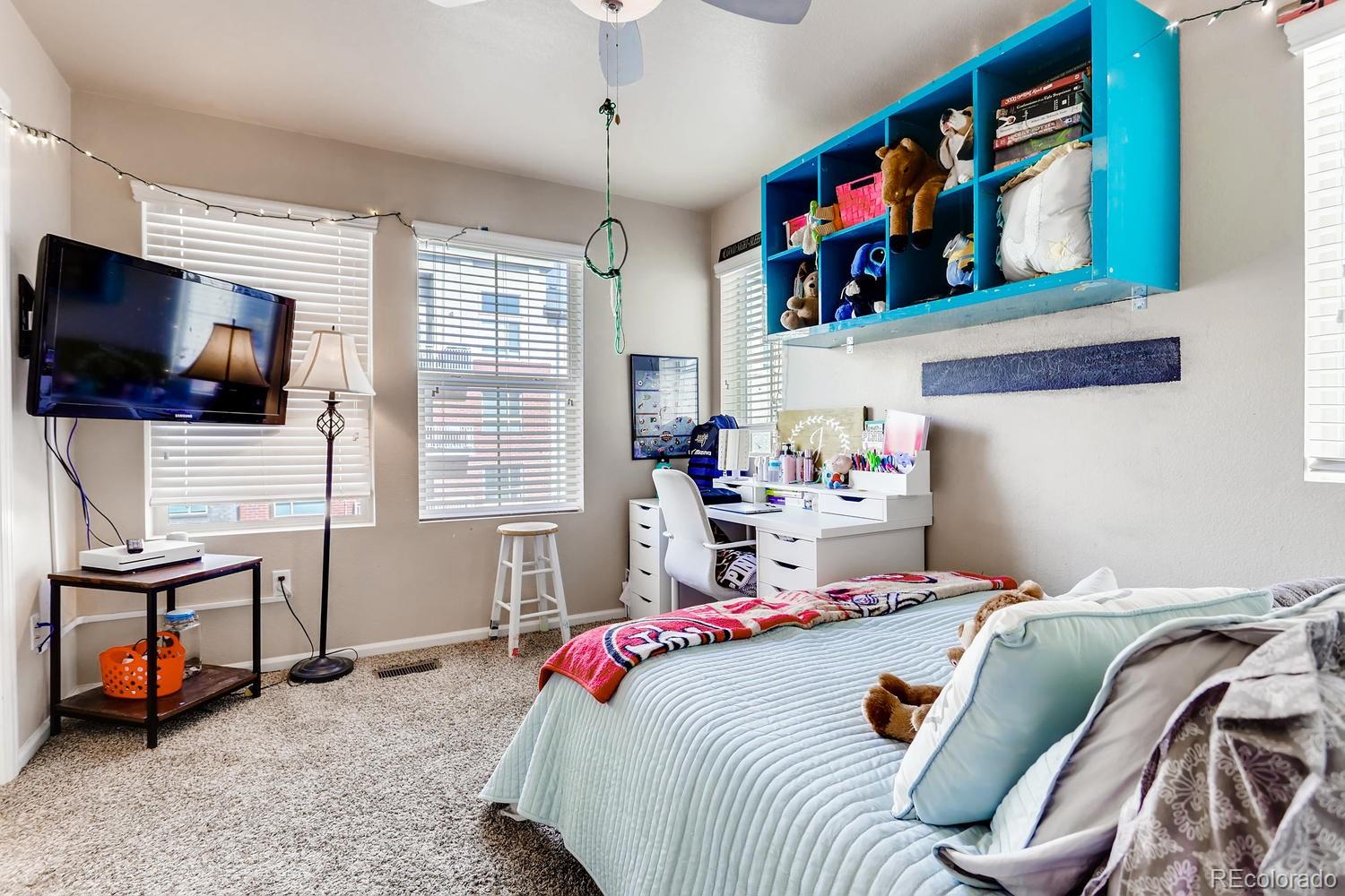 9520 Halstead Lane Lone Tree, CO 80124 - Photo 13 of 20 a bedroom with a bed a flat screen tv and a bookshelf