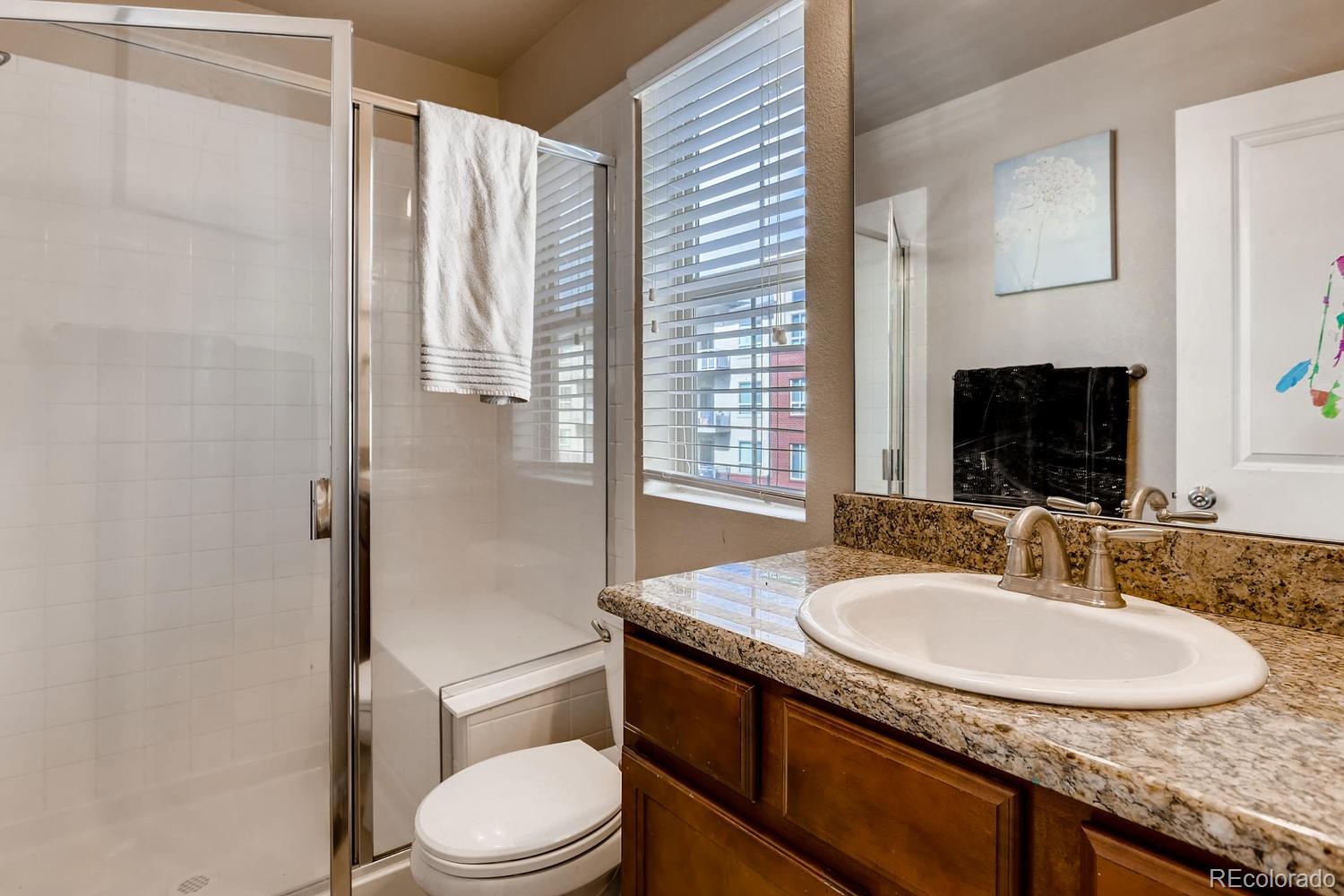 9520 Halstead Lane Lone Tree, CO 80124 - Photo 14 of 20 a bathroom with a granite countertop sink toilet and shower