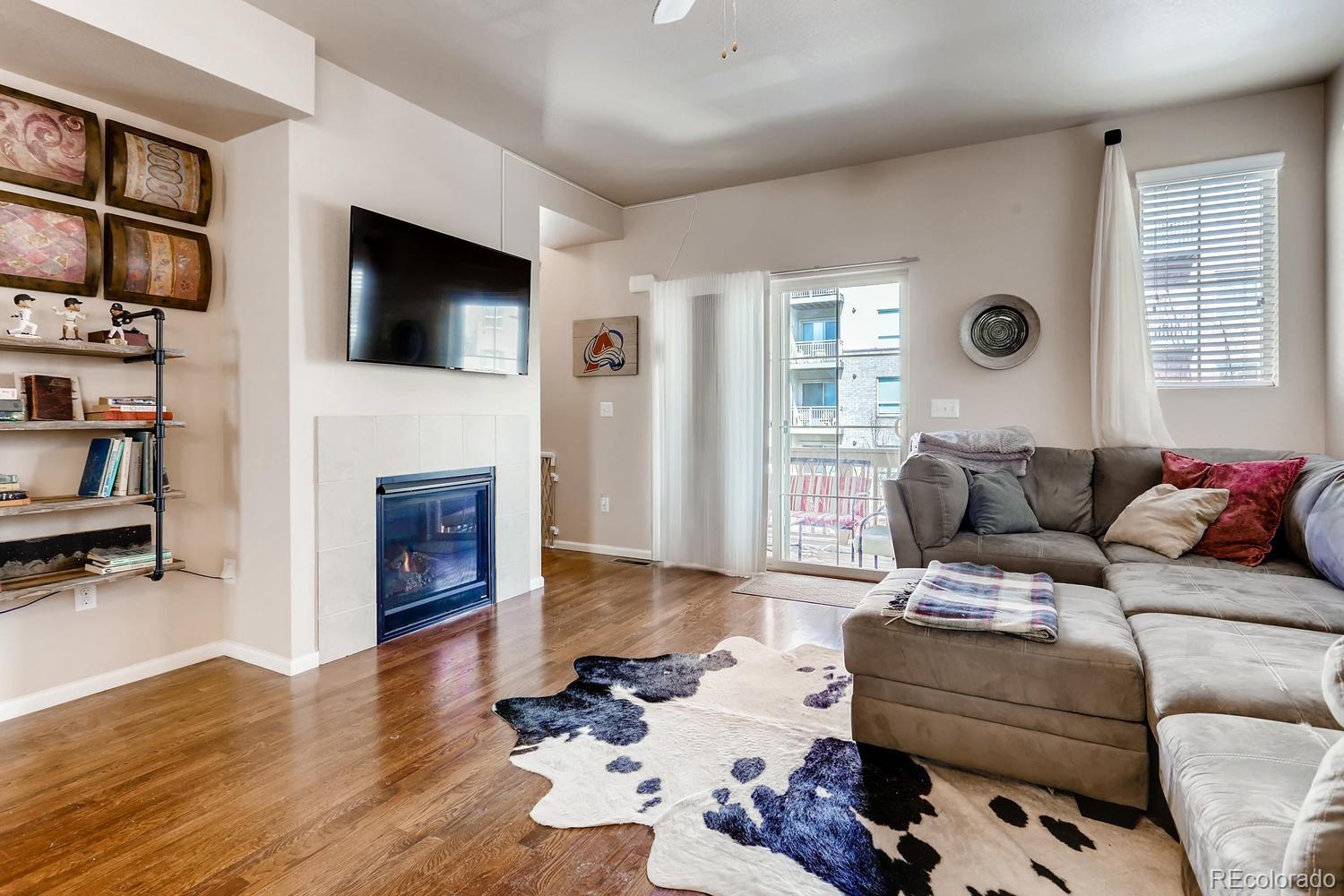 9520 Halstead Lane Lone Tree, CO 80124 - Photo 2 of 20 a living room with furniture a flat screen tv and a fireplace