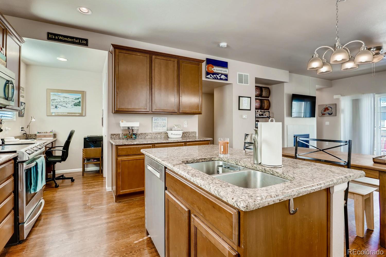 9520 Halstead Lane Lone Tree, CO 80124 - Photo 5 of 20 a kitchen with stainless steel appliances granite countertop a sink dishwasher a refrigerator and a stove with wooden floor