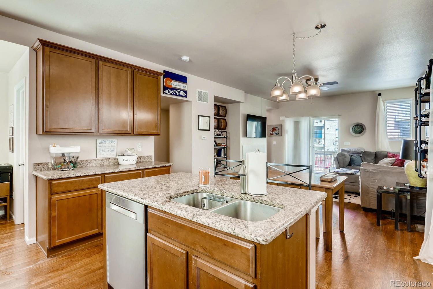 9520 Halstead Lane Lone Tree, CO 80124 - Photo 7 of 20 a kitchen that has a lot of cabinets a sink and wooden floor
