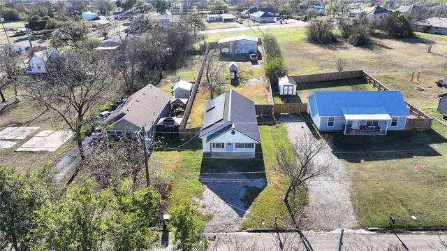 an aerial view of a house with a yard and trees