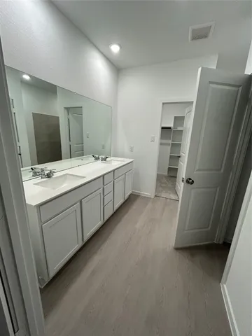 a room with a sink and a large mirror
