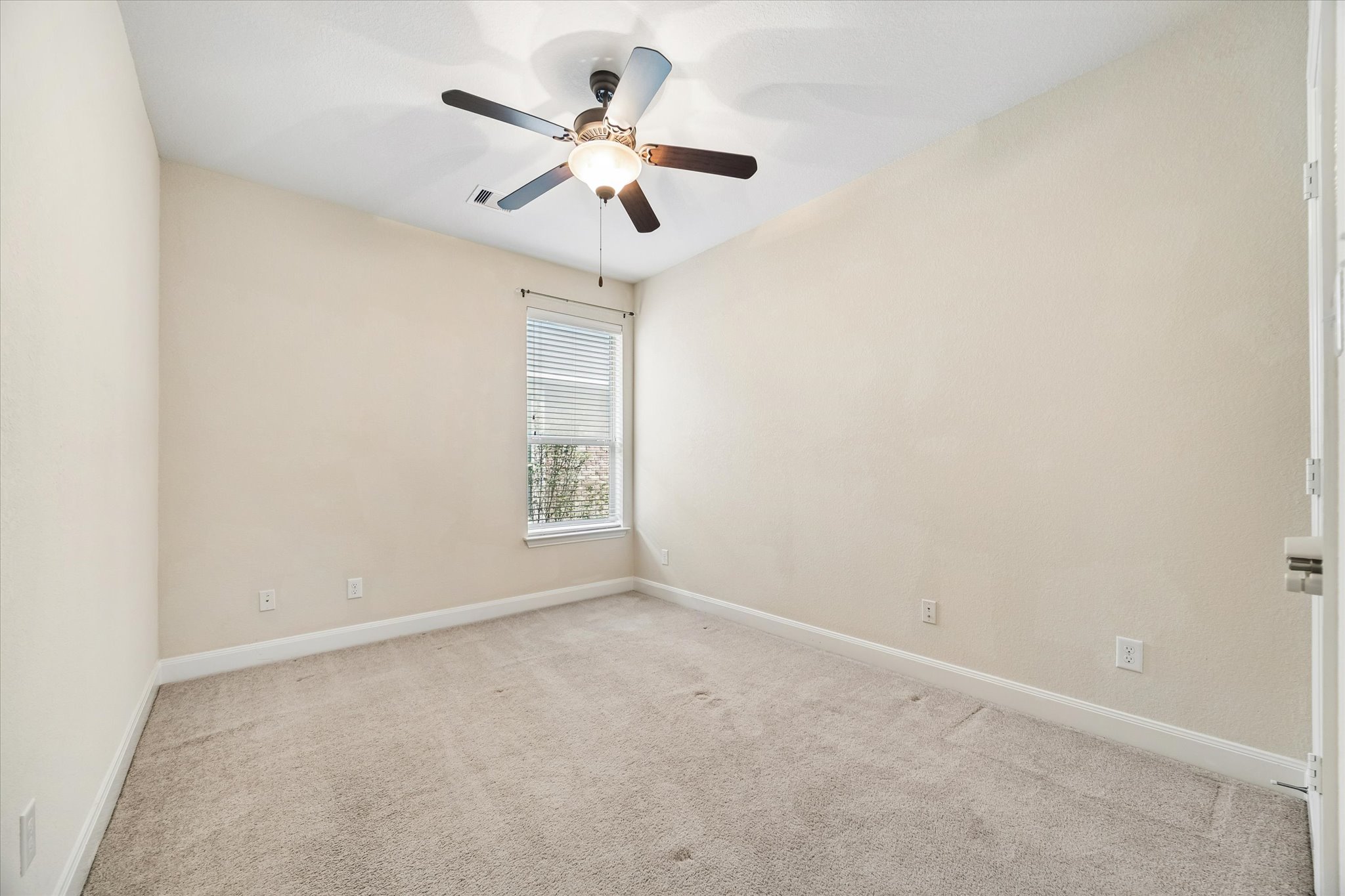 2214 Wembley Way Rosenberg, TX 77471 - Photo 32 of 35 Neutral-toned room featuring light beige walls and complementing carpet flooring
