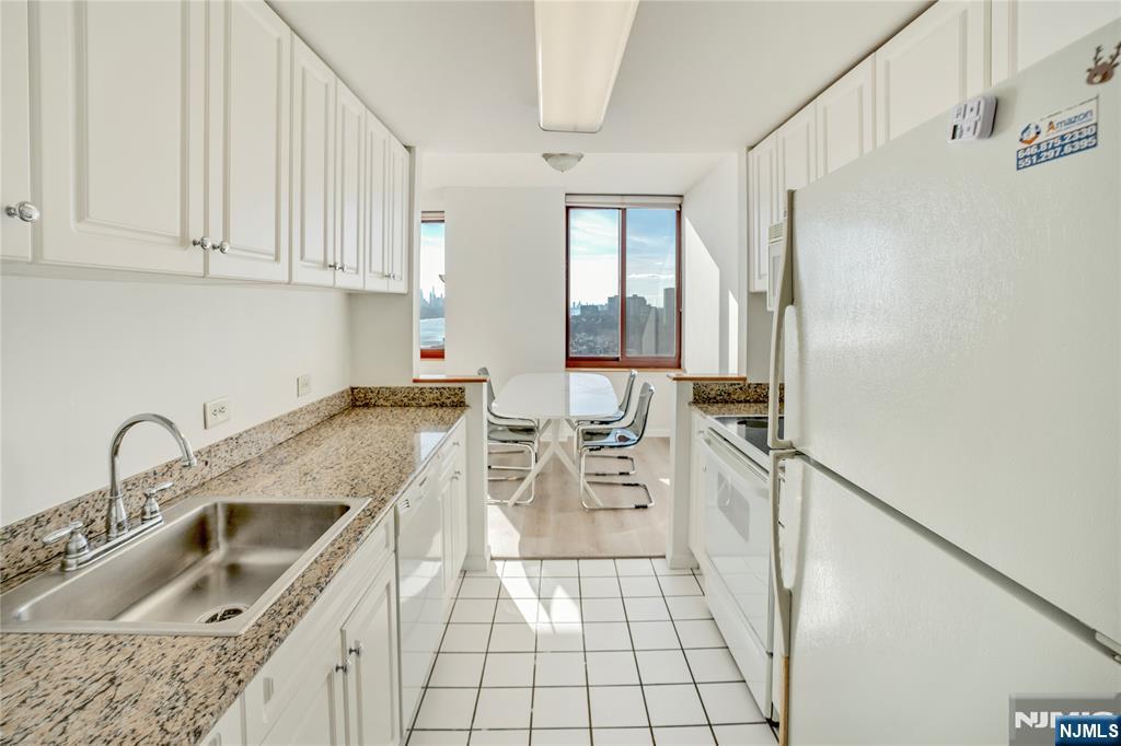 100 Old Palisade Road, Unit 2709 Fort Lee, NJ 07024 - Photo 7 of 15 a kitchen with a sink a stove and cabinets