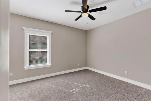 an empty room with a window and a fan
