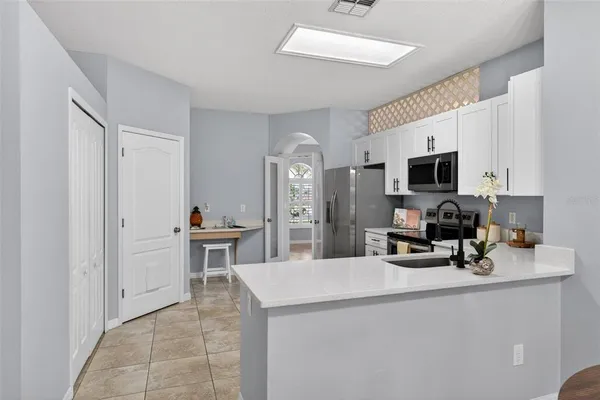 a kitchen with a sink a stove and cabinets