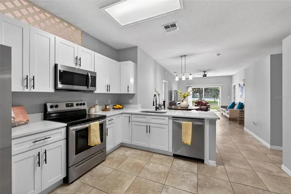 a kitchen with stainless steel appliances granite countertop a stove top oven a sink dishwasher and a refrigerator