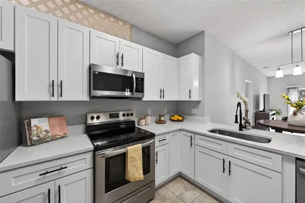 a kitchen with cabinets stainless steel appliances a sink and a stove