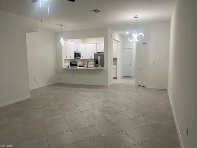 a view of a big room with kitchen and chandelier