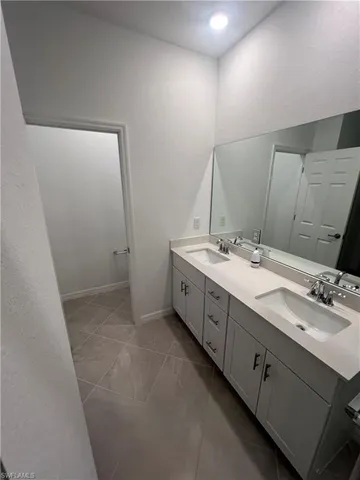 a spacious bathroom with a double vanity sink and mirror
