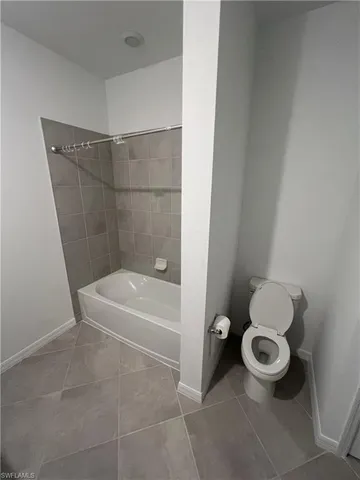 a bathroom with a toilet and a bath tub