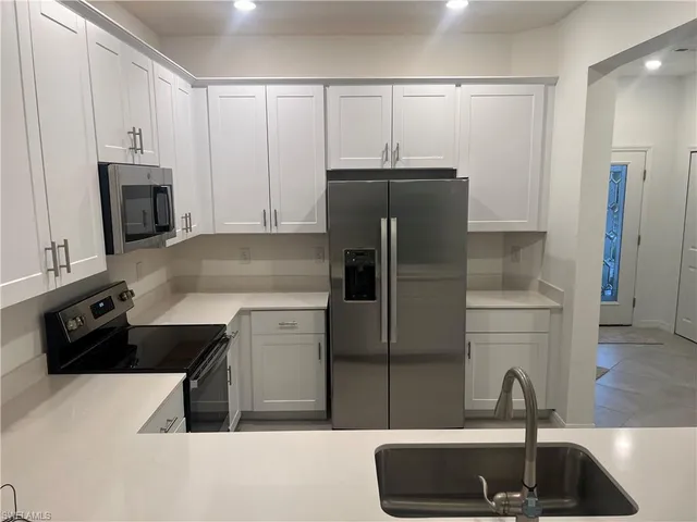 a kitchen with granite countertop a refrigerator and a sink