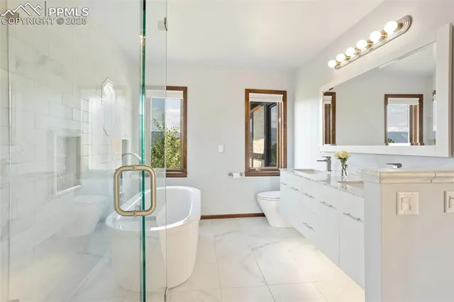 a spacious bathroom with a tub double sink window and mirror