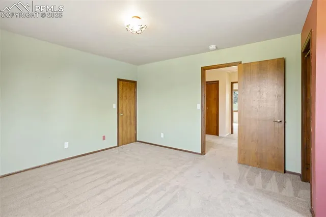 an empty room with closet and windows