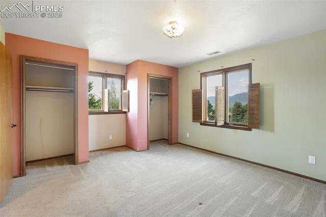 an empty room with windows and closet