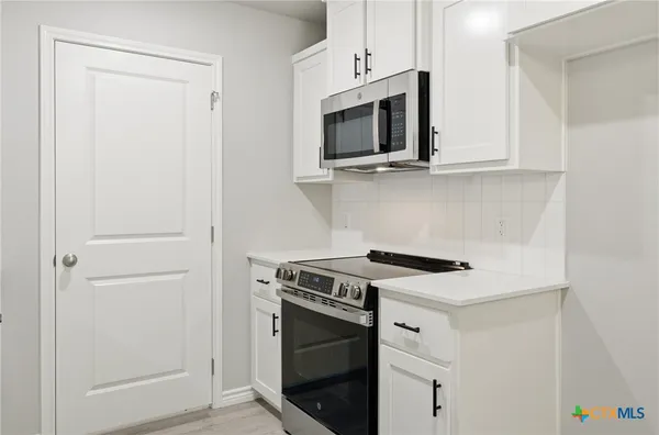 a kitchen with a stove and a microwave