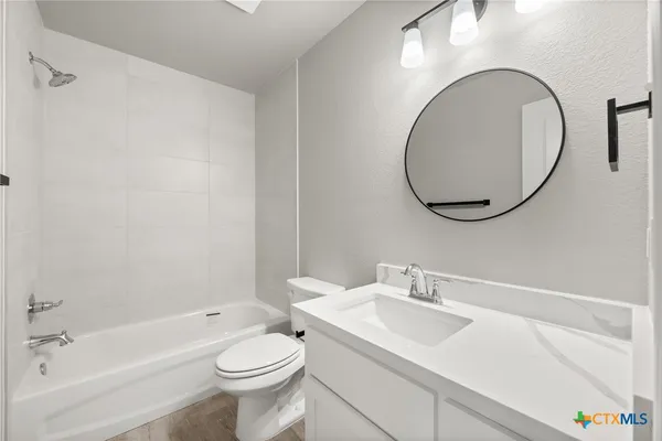 a bathroom with a sink a toilet and a mirror