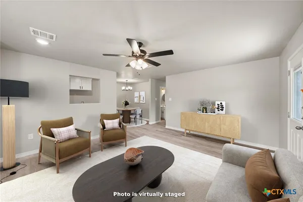 a living room with furniture and a ceiling fan