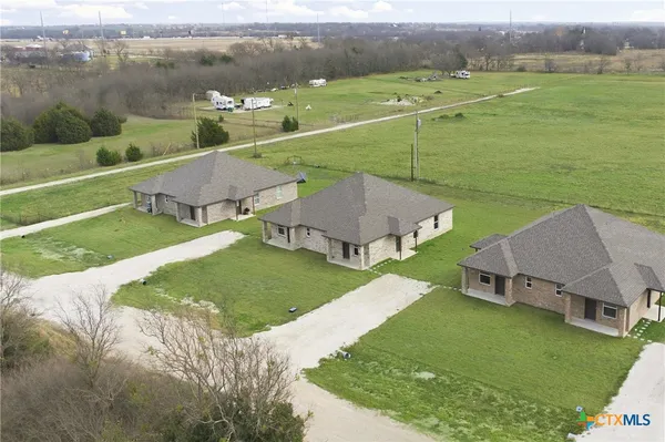 an aerial view of a house with a garden and lake view