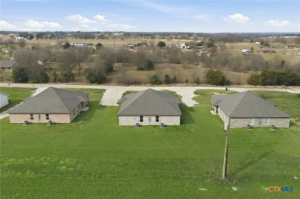 an aerial view of residential houses with outdoor space and lake view