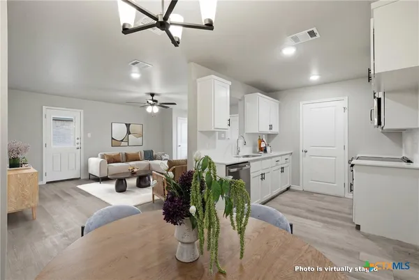 a large white kitchen with white cabinets and stainless steel appliances