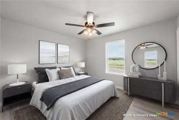 a bedroom with a bed a mirror on dresser and a chandelier