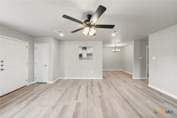 a view of empty room with wooden floor