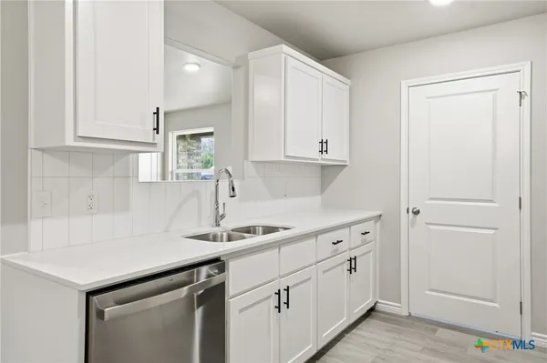 a kitchen with white cabinets and white appliances
