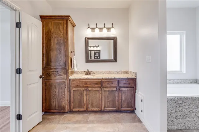 a en suite bathroom with a tub sink and mirror