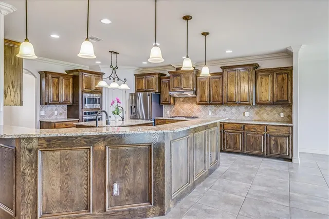 a large kitchen with kitchen island granite countertop a sink a stove and a wooden floors