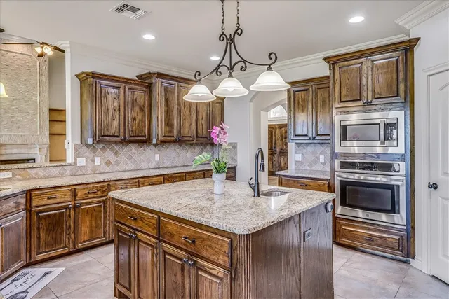 a kitchen with stainless steel appliances granite countertop a sink a stove and a refrigerator