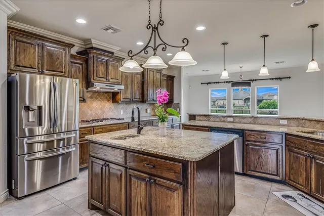 a kitchen with stainless steel appliances granite countertop a sink refrigerator and cabinets