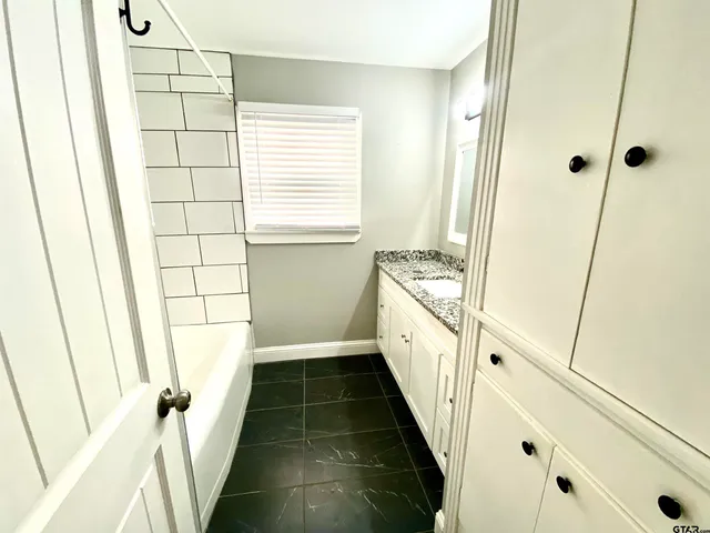a bathroom with a sink a toilet a window and vanity