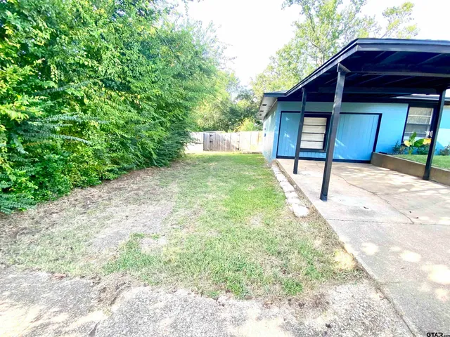 a view of a house with a yard and wooden fence
