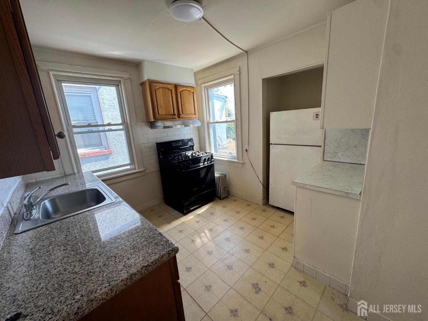 110 Rector Street, Unit 2 Perth Amboy, NJ 08861 - Photo 8 of 11 a kitchen with granite countertop a refrigerator sink and stove