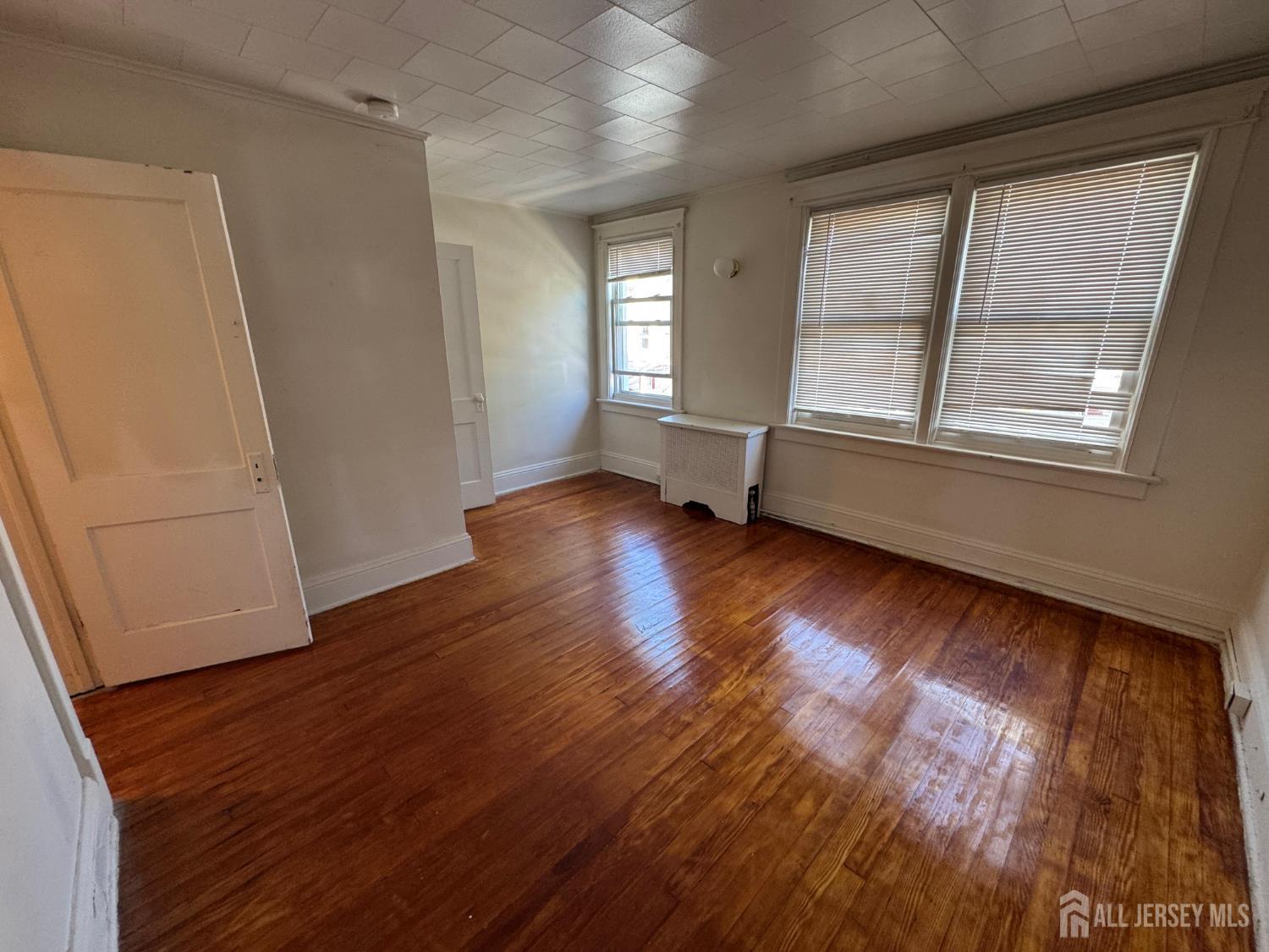 110 Rector Street, Unit 2 Perth Amboy, NJ 08861 - Photo 10 of 11 an empty room with wooden floor and windows