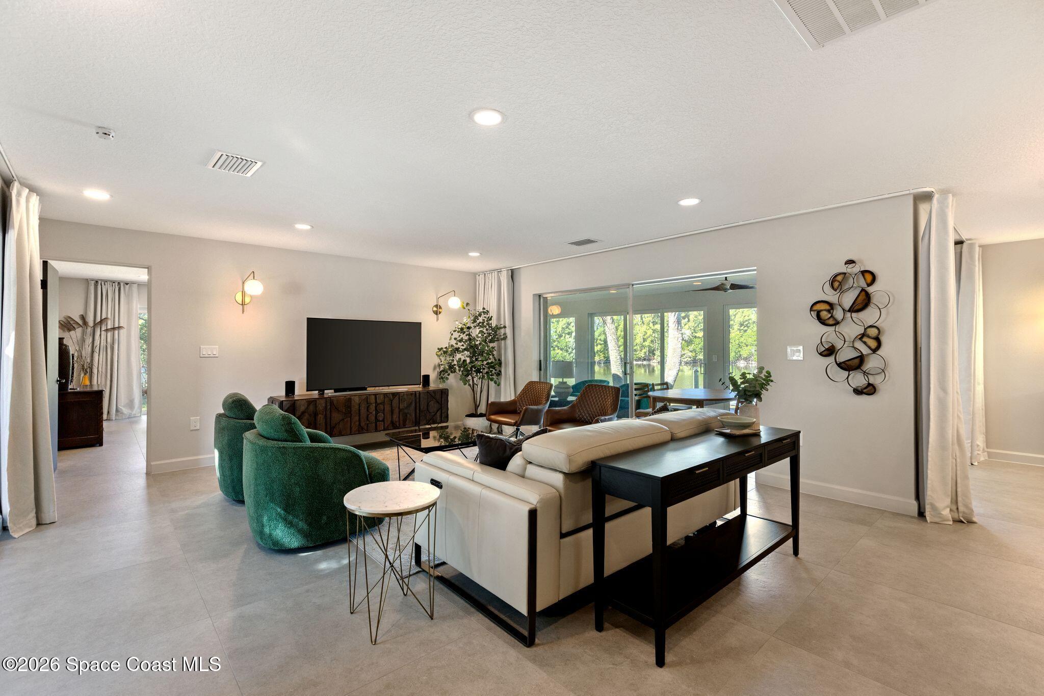 1224 Samar Road Cocoa Beach, FL 32931 - Photo 15 of 56 a living room with furniture and a flat screen tv