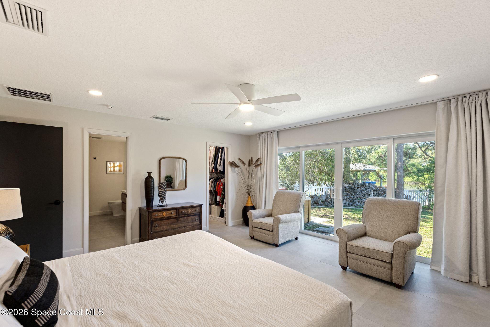 1224 Samar Road Cocoa Beach, FL 32931 - Photo 16 of 56 a bedroom with a bed and a large window