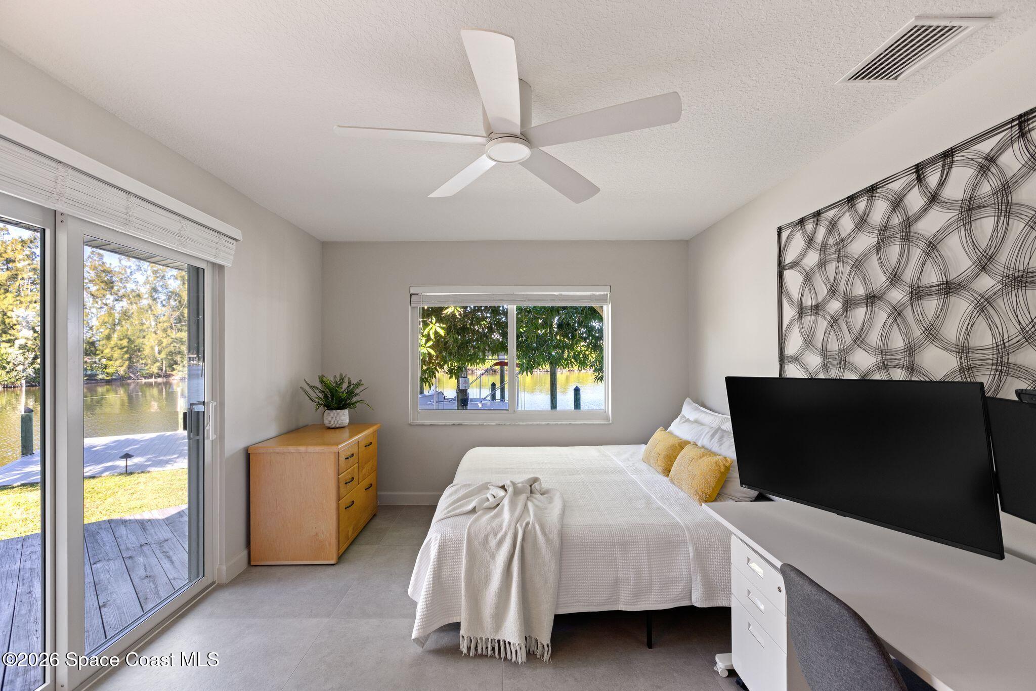 1224 Samar Road Cocoa Beach, FL 32931 - Photo 35 of 56 a bedroom with a bed and a flat tv screen on dresser