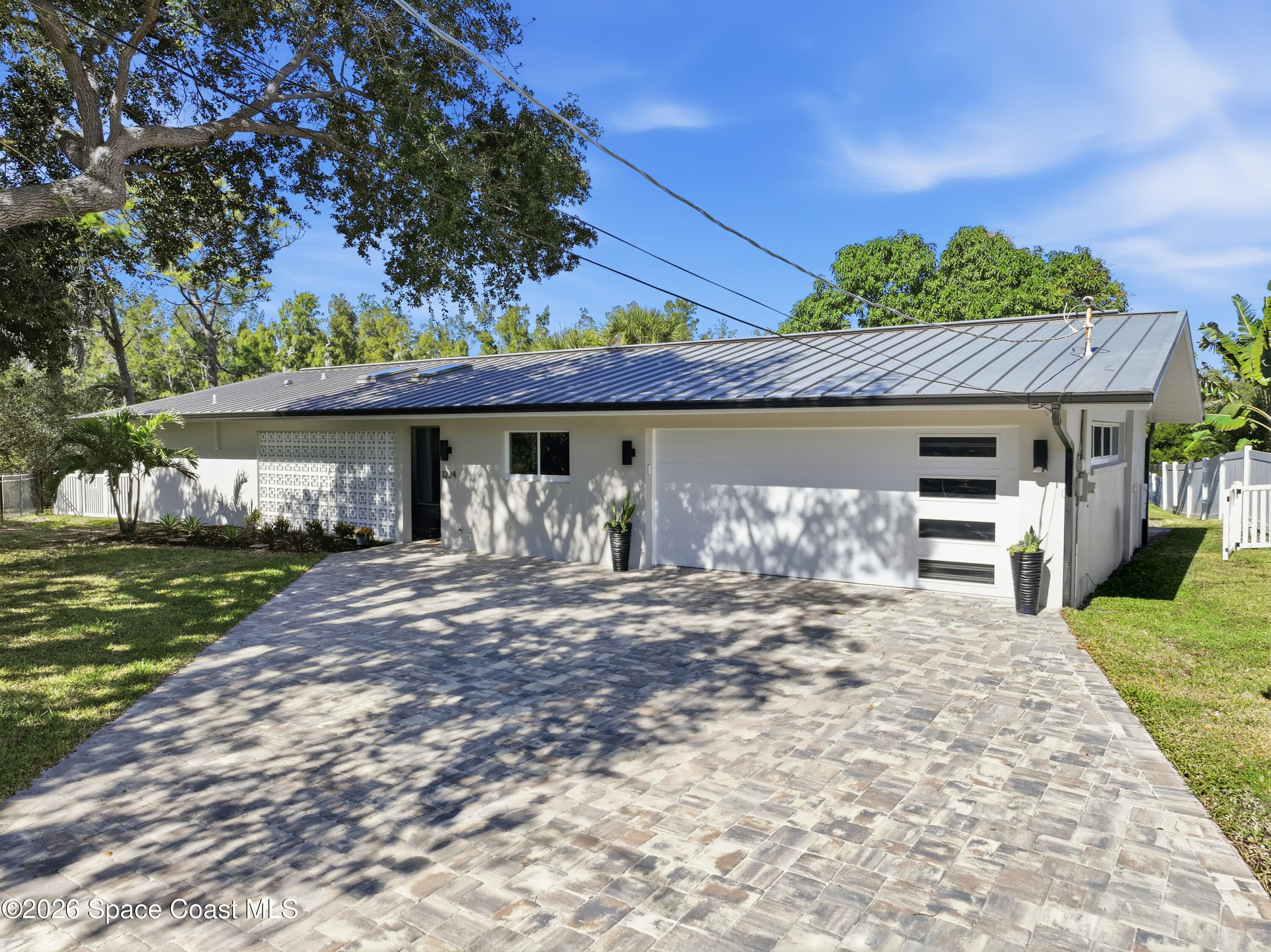1224 Samar Road Cocoa Beach, FL 32931 - Photo 41 of 56 a front view of a house with a garden and trees
