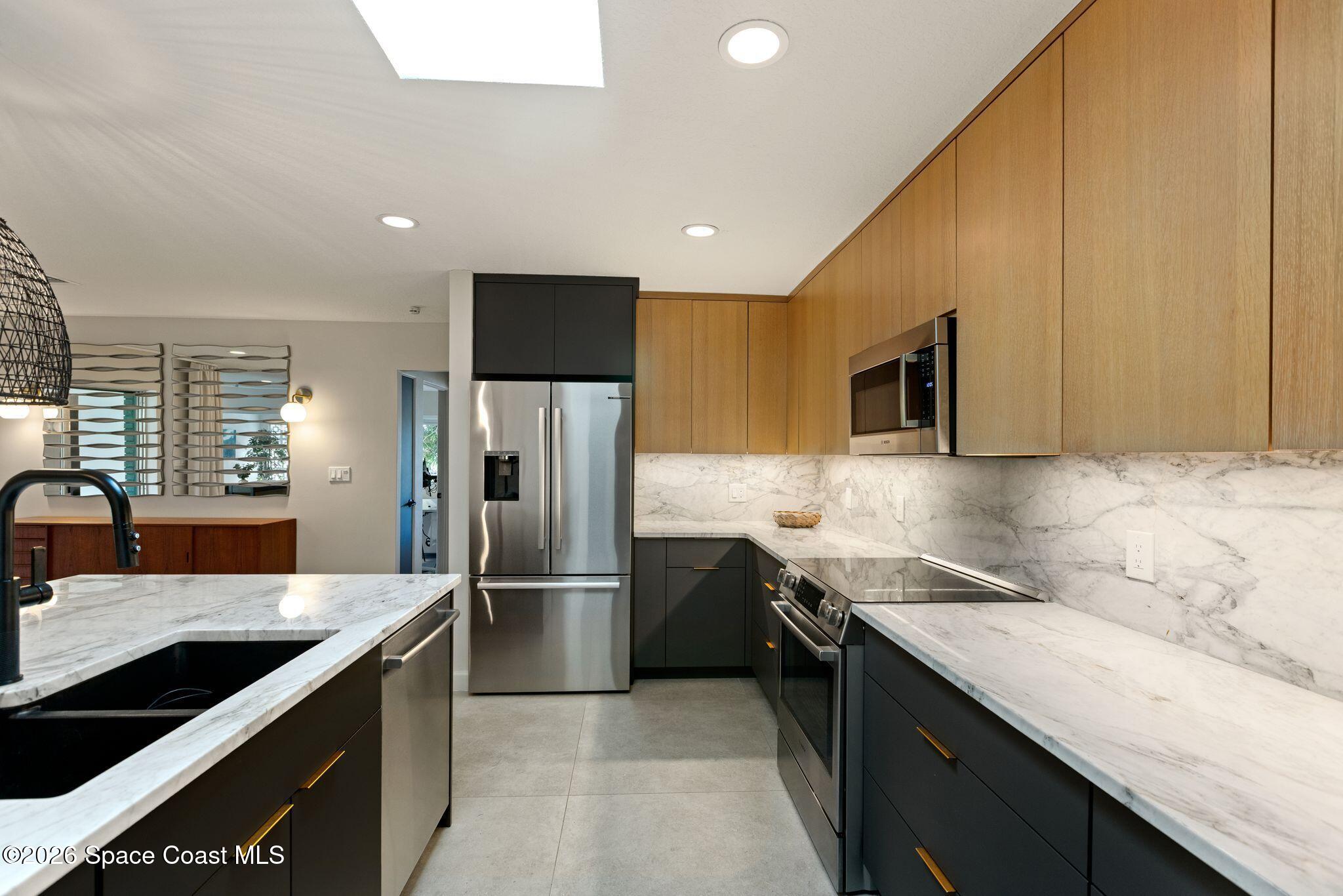 1224 Samar Road Cocoa Beach, FL 32931 - Photo 9 of 56 a kitchen with stainless steel appliances granite countertop a sink stove and refrigerator