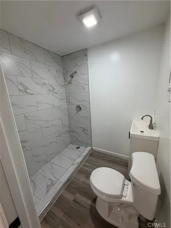 a white toilet sitting next to a bath tub shower