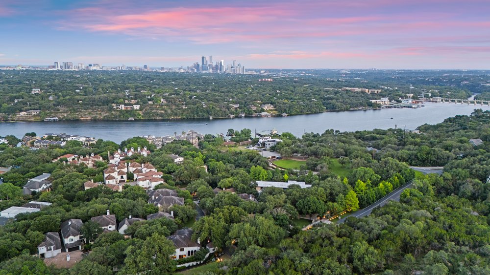 1815 Rue De St Tropez Austin, TX 78746 - Photo 2 of 40 Expansive natural landscape featuring a prominent river, dense tree canopy, distant cityscape, and residential properties