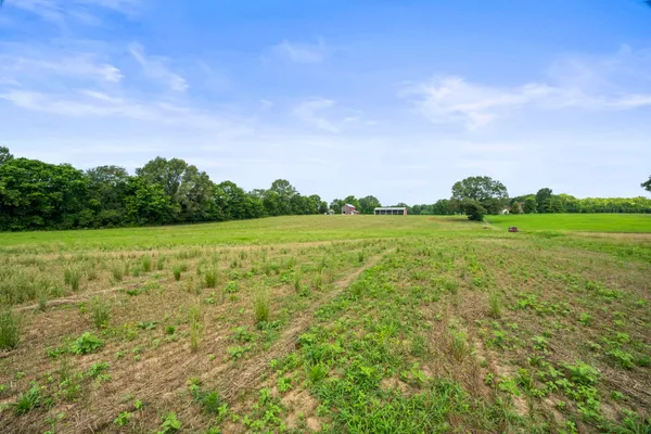 a view of a green field with wooden fence